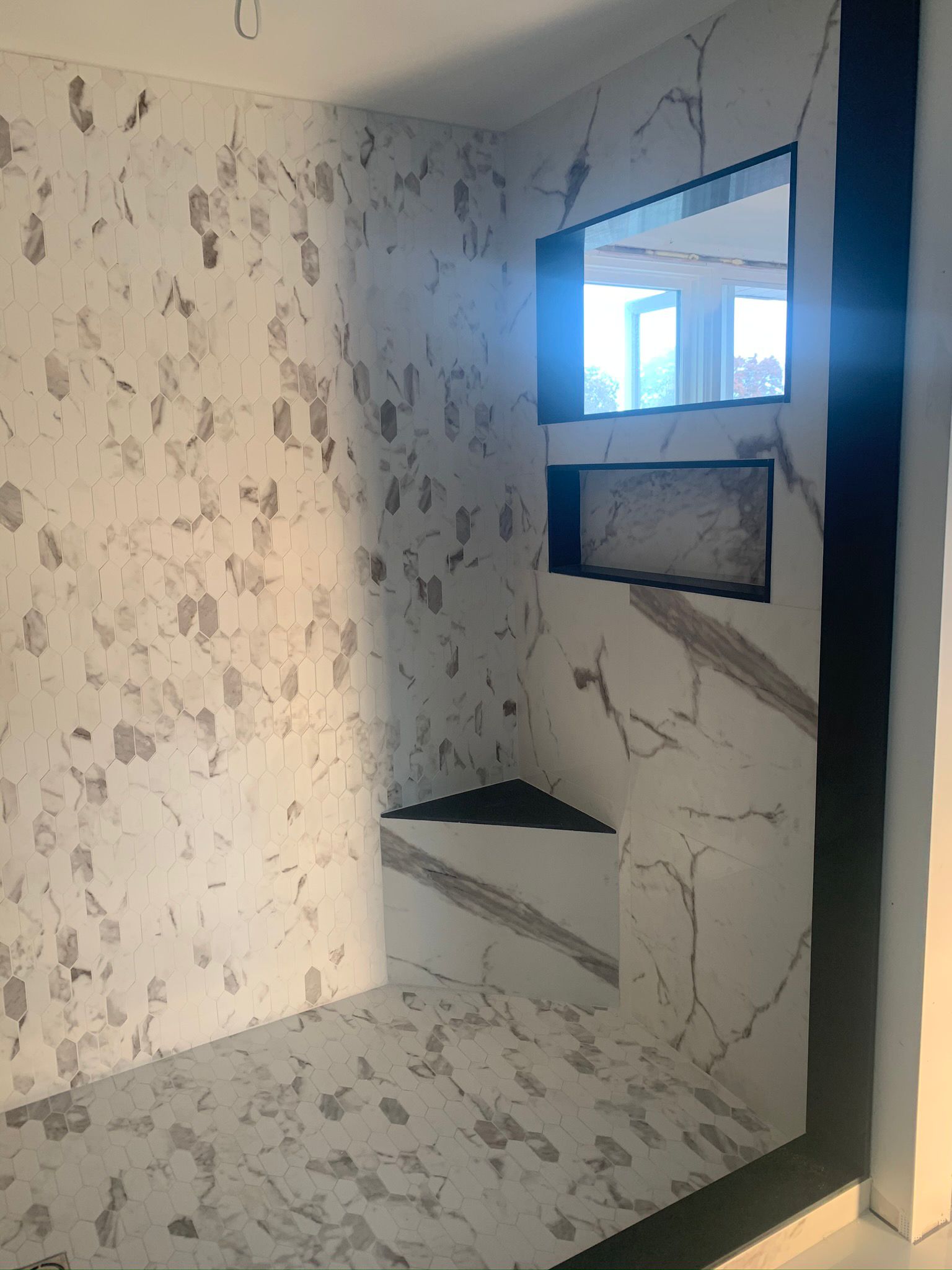Calacatta hex mosaic floor with marble bench